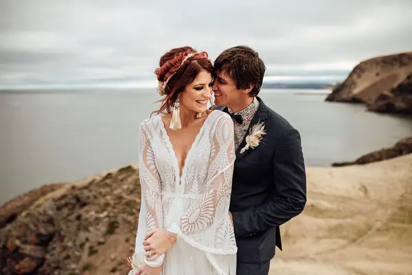 Bride and groom on a rocky coastline
